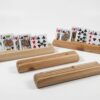 Four wooden playing card holders made from fir on a white background, with two holding face-up cards and two empty holders showing the three-slot design.